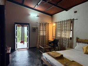 ein Schlafzimmer mit Bett und Tür zu einer Terrasse in der Unterkunft Vanacara in Sawantwadi