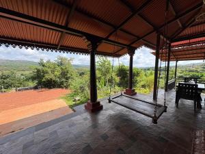 Ein Pavillon mit einer Bank und Blick auf die Berge in der Unterkunft Vanacara in Sawantwadi