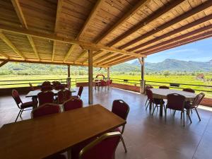 a room with tables and chairs and a view of a field at Hotel River in Gusinje
