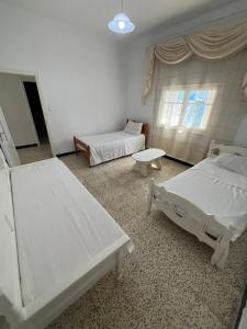 a hospital room with two beds and a table at Charmante maison à Hammamet, proche plage et commodités in Hammamet +8 photos