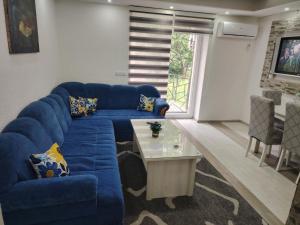 a living room with a blue couch and a table at Apartman Archy in Sarajevo