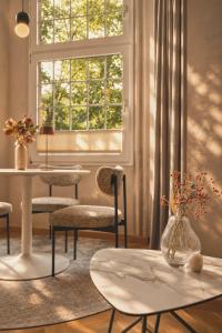 a living room with chairs and a table and a window at Stylish City Center Escape- Where Modern Elegance Meets History in Trier