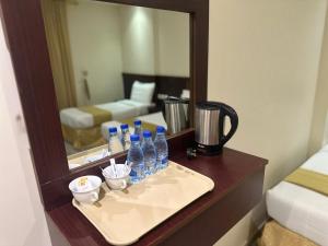 a bathroom with a vanity with bottles and a mirror at غرف تاج الذهبية الملاوي in Mecca