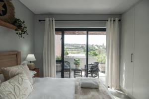 a bedroom with a bed and a table with chairs at Lovemore Retreat in Gqeberha +33 photos