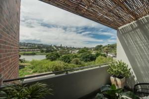 a balcony with a view of a river at Lovemore Retreat in Gqeberha