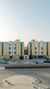 a large building with cars parked in a parking lot at هوليدي الخليج الفندقية Holiday Alkhaleej in Riyadh