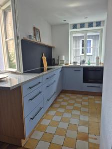 a kitchen with white cabinets and a tile floor at Bei Jakobus in Künzelsau