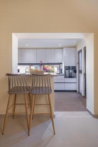 a kitchen with two chairs sitting at a counter at TheraLiving - Boutique Apartment with Balcony in Afantou