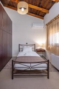 a bedroom with a bed and a wooden ceiling at TheraLiving - Boutique Apartment with Balcony in Afantou