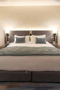 a large bed in a bedroom with two lamps at هوليدي الخليج الفندقية Holiday Alkhaleej in Riyadh
