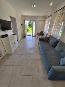 a living room with a couch and a television at Barlang utca Villa in Cserszegtomaj