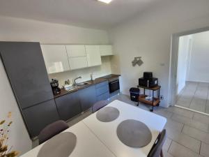 a kitchen with a table and chairs in a room at Barlang utca Villa in Cserszegtomaj