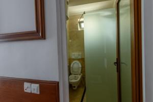 a bathroom with a toilet and a glass door at Boutique Hotel 89 in Peje