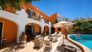 a courtyard with a pool and chairs and a building at Hotel Aragonese Ischia in Ischia Town
