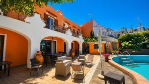 a resort with a swimming pool and tables and chairs at Hotel Aragonese Ischia in Ischia Town
