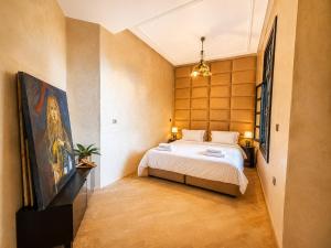 a bedroom with a bed and a painting on the wall at Nassau House Marrakech in Mellah Bakka +99 photos