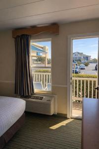 a hotel room with a bed and a balcony at The Sea Ranch Resort in Kill Devil Hills +53 photos