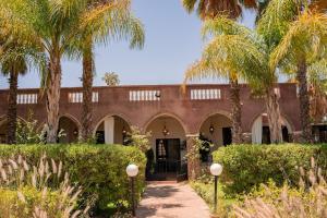 a courtyard with palm trees and a building at Nassau House Marrakech in Mellah Bakka