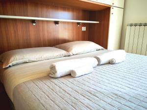 a bed with two rolled towels on top of it at VistaMare Bluemar - Garden & Sea in Cattolica +22 photos