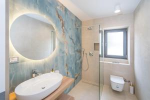 a bathroom with a sink and a toilet and a mirror at Villa Cvita west in Primošten +21 photos