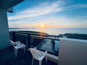 a balcony with two chairs and a view of the ocean at Sea Quilt Bed and Breakfast in Xujiacun