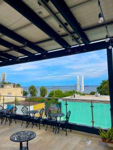 a patio with tables and chairs and a swimming pool at RIG Puerto Malecón in Santo Domingo