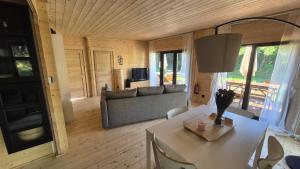a living room with a table and a couch at Les Ecolodges du Lac in Chambon-sur-Lac