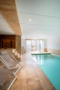 a swimming pool with chairs in a building at Les Gîtes de Sprimont - Le Cottage in Sprimont