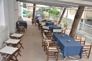 a row of tables and chairs with blue tables at Hotel Garden in Lignano Sabbiadoro +35 photos