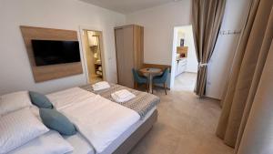 a small bedroom with a bed and a small table at Apartments Cassia in Mali Lošinj