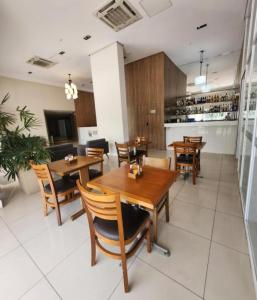 a dining room with wooden tables and chairs at Flat & Suite Premium - Rio Centro - Barra - Farmasi Arena in Rio de Janeiro