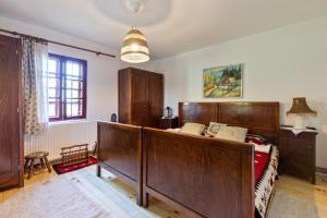 a bedroom with a bed with wooden furniture and a window at Tri breze Vodanj in Vodanj