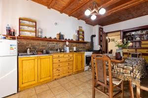 a kitchen with wooden cabinets and a white refrigerator at Tri breze Vodanj in Vodanj +12 photos