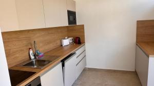 a kitchen with white cabinets and a sink at Apartments Cassia in Mali Lošinj