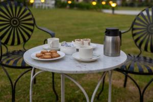 a table with cups and plates of food on it at Aayovea Resort Ayodhya Near Ram Mandir & Saryu River in Ayodhya +77 photos