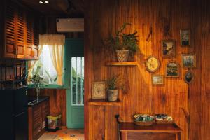 a kitchen with wooden walls and a table with plants at Đàng Trong Home 2 in Xóm Rạch Rô