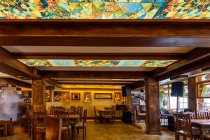 a room with tables and chairs and a stained glass ceiling at Boutique Hotel 89 in Peje