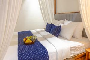 a bedroom with a bed with a bowl of fruit on it at Aayovea Resort Ayodhya Near Ram Mandir & Saryu River in Ayodhya