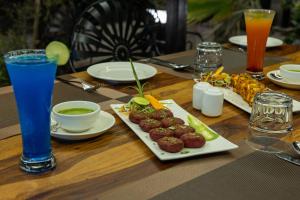 a wooden table with plates of food and drinks at Aayovea Resort Ayodhya Near Ram Mandir & Saryu River in Ayodhya