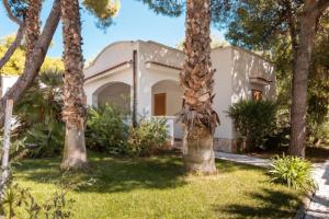 a house with palm trees in front of it at Villaggio Baia Dei Lombardi in Vieste