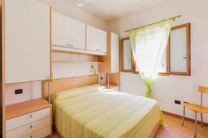 a bedroom with a bed and a dresser and a window at Villaggio Baia Dei Lombardi in Vieste
