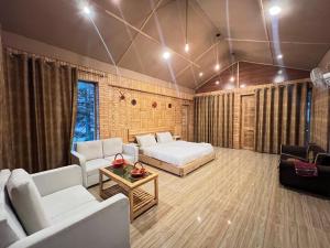 a living room with a bed and a couch at Relax Cottages & Resort Kalam in Kalām +50 photos
