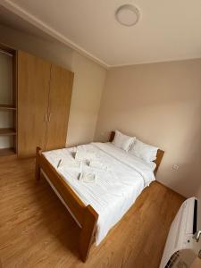 a bedroom with a large bed with white sheets at Apartmani Ljupko in Pančevo