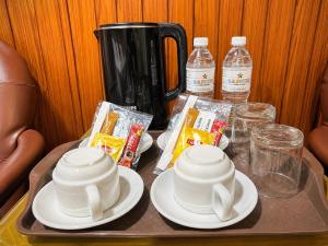 a tray with plates and cups and drinks on a table at SS Hotel Seremban in Seremban