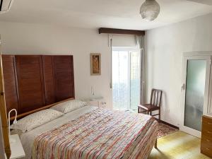 a bedroom with a bed and a chair and a window at Casa Il Muro in Citta' Sant'Angelo
