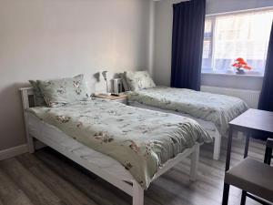 a bedroom with two beds and a window at Orient Short Stay in Holyhead