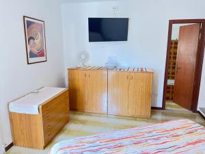 a bedroom with a bed and a dresser and a tv at Casa Il Muro in Citta' Sant'Angelo
