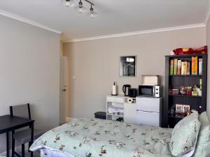 a bedroom with a bed and a microwave and a table at Orient Short Stay in Holyhead +2 photos