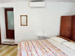 a white bedroom with a bed and a mirror at Casa Il Muro in Citta' Sant'Angelo