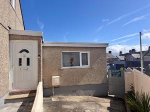 a house with a white door and a window at Orient Short Stay in Holyhead